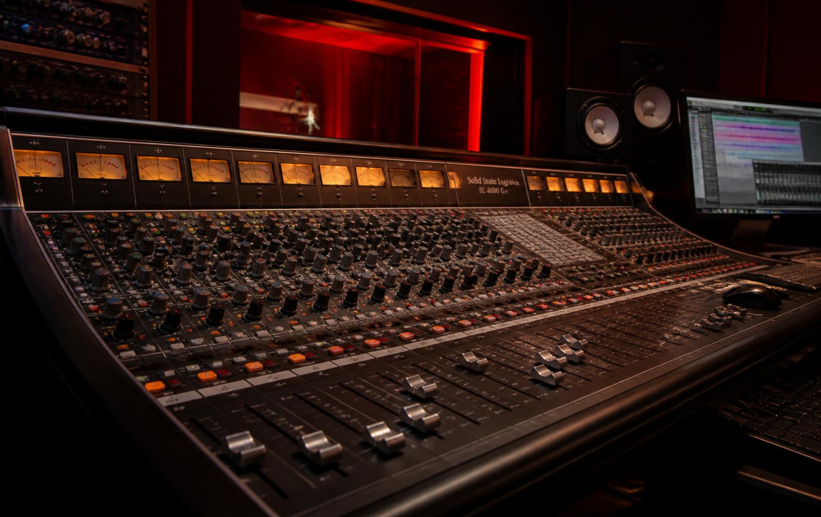 Recording studio mixing console lit in red